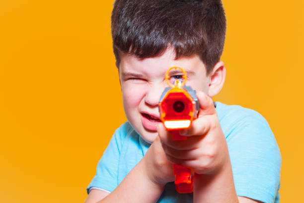 ragazzo che gioca con la pistola di plastica - toy gun foto e immagini stock