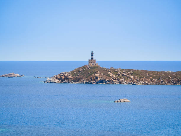 istock Lighthouse on a promontory surrounded by the blue sea. 1063453120