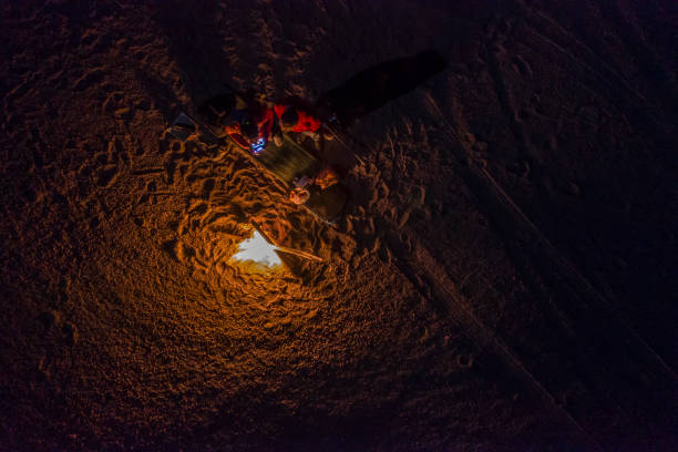 terwijl het zoeken van meteorieten op atacama woestijn maakten we een stop voor het slapen in het midden van de verbazingwekkende atacama woestijn. een luchtfoto van het kampvuur onder het licht van de volle maan op een sterrennacht. chili - chili fire stockfoto's en -beelden