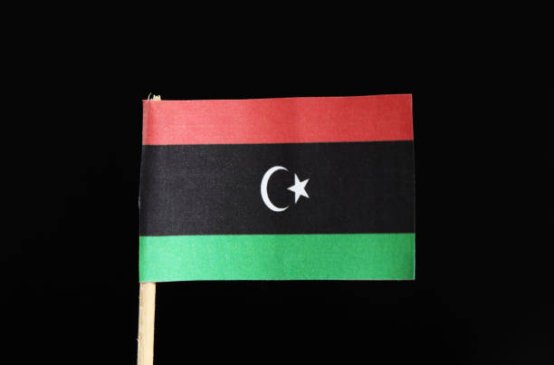 un drapeau officiel de la libye sur un cure-dent sur fond noir. se compose d’un tribande horizontal de rouge, noir et vert avec screscent et étoile blanche, centré sur la rayure noire - mosque of al bayda photos et images de collection