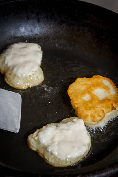 istock Cooking pancakes on a black pan with oil 1063459890