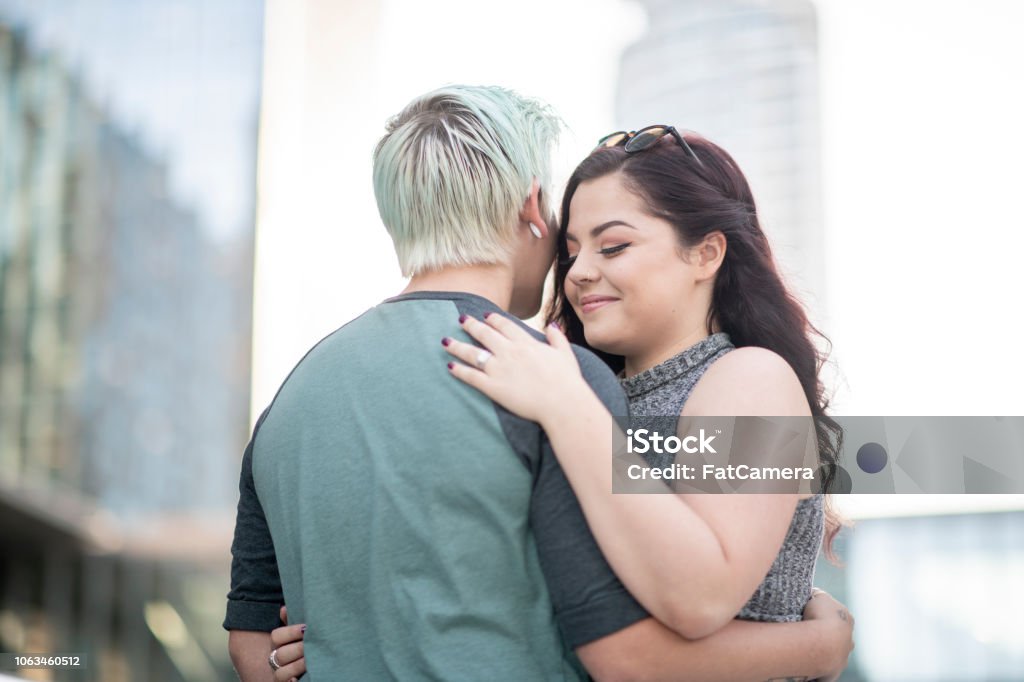 Hugging Outdoors A lesbian couple are hugging outdoors. It's a sunny day in the downtown of a big city. 18-19 Years Stock Photo
