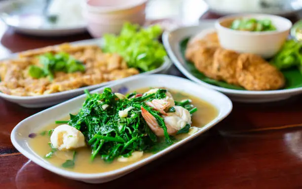 Photo of Stir-fried Vegetable fern with shrimp in white dish on wooden table