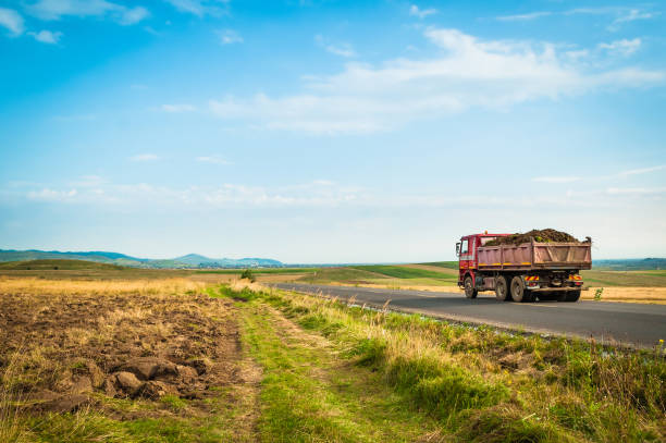 istock Truck on long road in open field 1063466462