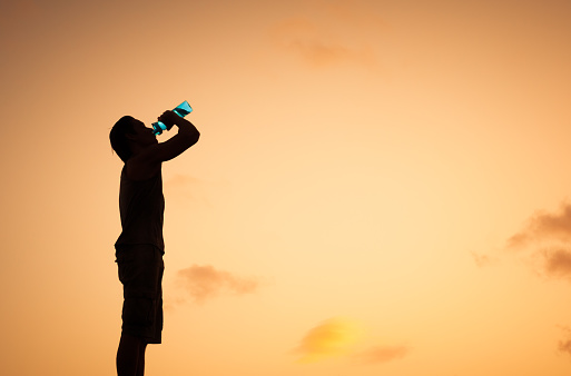 Man drinking water after run. Healthy lifestyle concept.
