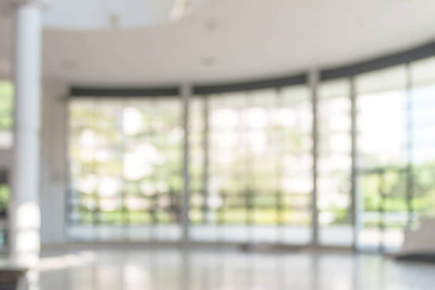 istock Blur background interior view looking out toward to empty office lobby and entrance doors and glass curtain wall 1063497942