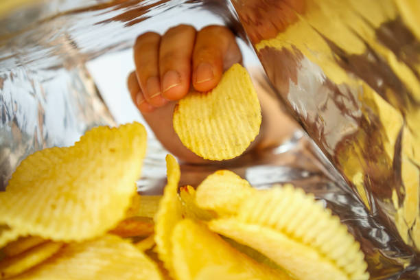 istock Hand hold potato chips inside snack foil bag 1063498256