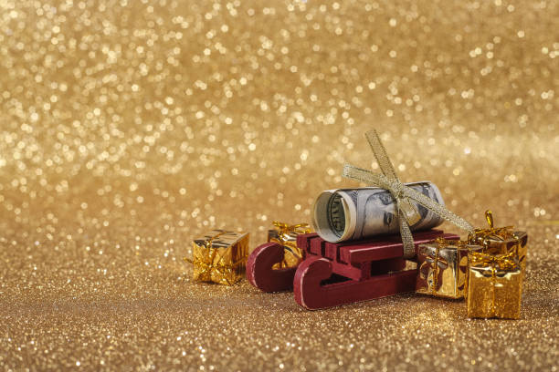 Christmas ball on gold glitters Christmas money gift on abstract gold glitters bokeh background euro bill in a christmas ornament stock pictures, royalty-free photos & images