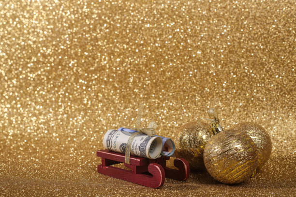 Christmas ball on gold glitters Christmas money gift on abstract gold glitters bokeh background euro bill in a christmas ornament stock pictures, royalty-free photos & images