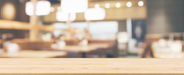 istock Wood table top with abstract blurred cafe restaurant with bokeh lights defocused background 1063498368