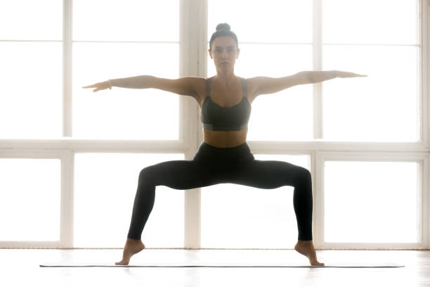 istock Young sporty attractive woman practicing yoga, doing Sumo Squat exercise 1063498434