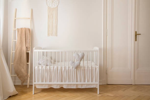 escandinavo berçário com berço de madeira branco e macramê na parede da casa de cortiço, foto real com espaço de cópia - quarto de bebê - fotografias e filmes do acervo