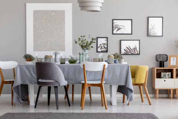 istock White ,grey and yellow chair at table with tableware in dining room interior with posters. Real photo 1063499010