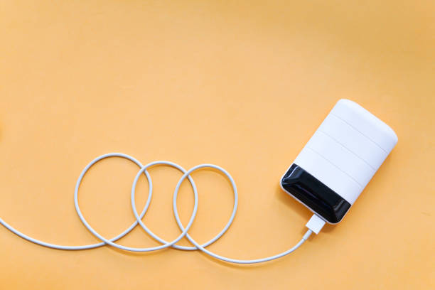 Power Bank with Spiral USB Cable on Orange Background Top View