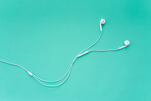 Earphones for Smartphone Isolated on Turquoise Background Top View