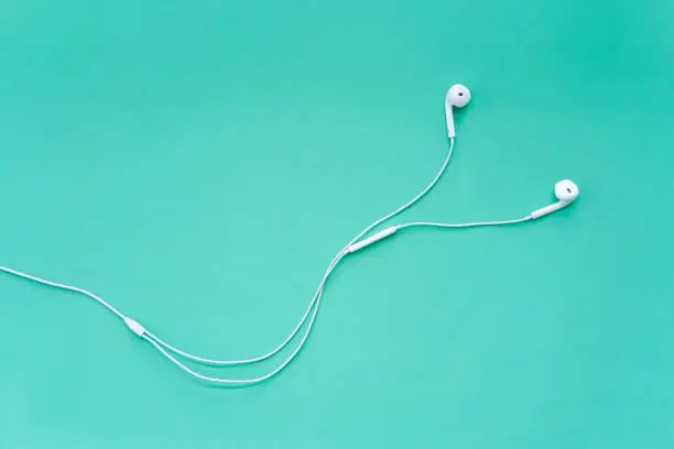 Photo of Earphones for Smartphone on Turquoise Background Top View