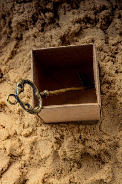 istock Retro style key in a brown box on sand 1063557830