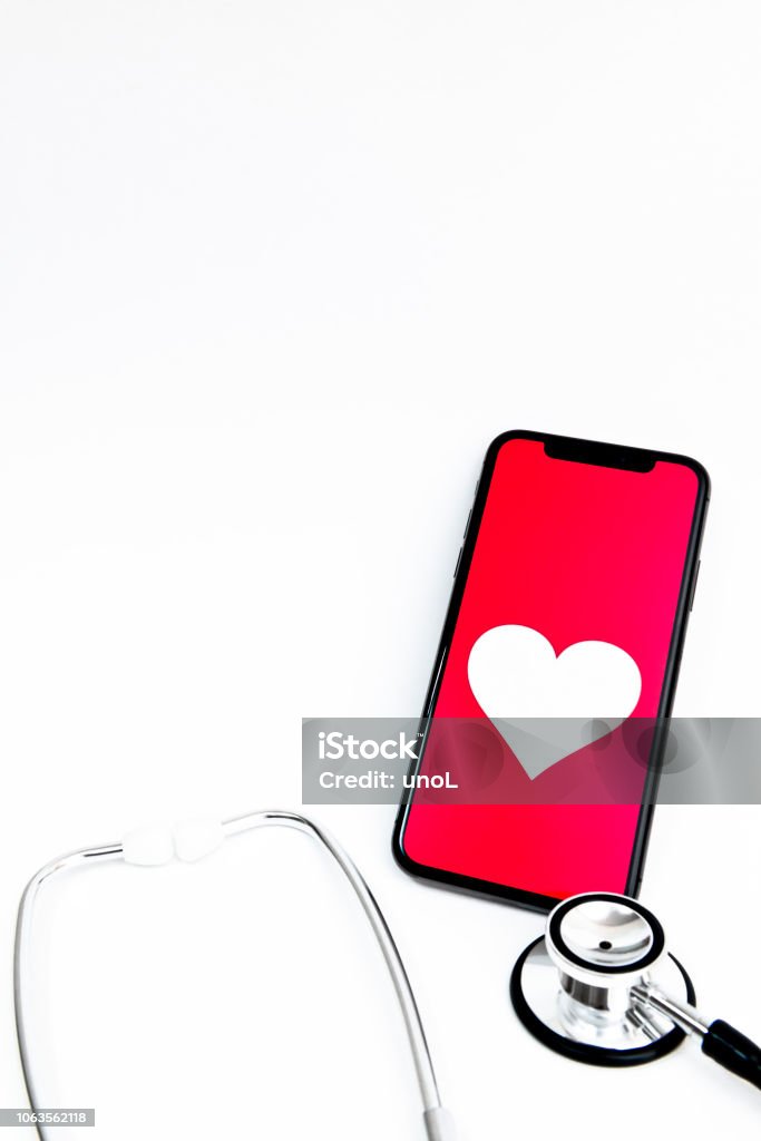 Mobile health care services by smart phone Smart phone and stethoscope on white backgroundsRed heart, Smart phone and stethoscope on white backgrounds Healthcare And Medicine Stock Photo