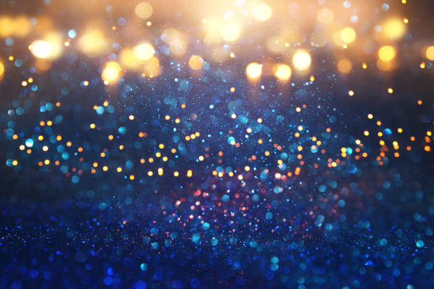 istock glitter vintage lights background. black, gold and blue. de-focused. 1063572270