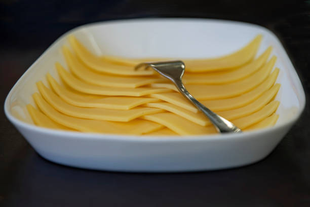 istock Sliced yellow cheese on white plate close up 1063579048