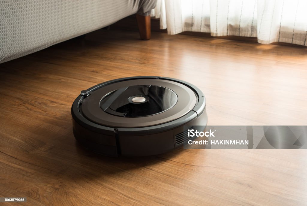 Robot vacuum cleaner on wood,laminate floor.Smart life concepts Robot vacuum cleaner on wood,laminate floor.Smart life concepts ideas Robotic Vacuum Cleaner Stock Photo