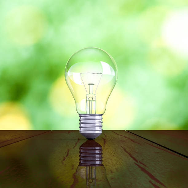 istock Light bulb on wooden table with green nature background 1063592742