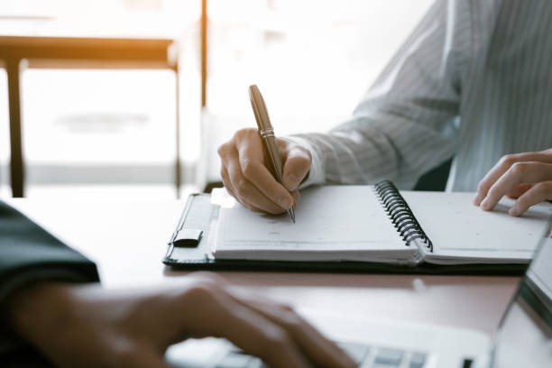 istock Consultant making note summary report with manager using laptop on desk in office room. 1063593158