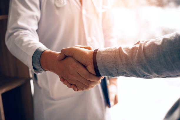 doctor shaking hands with patient in the clinic. - doctor patient greeting talking imagens e fotografias de stock