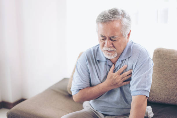 senior male asian suffering from bad pain in his chest heart attack at home - senior heart disease - peito imagens e fotografias de stock