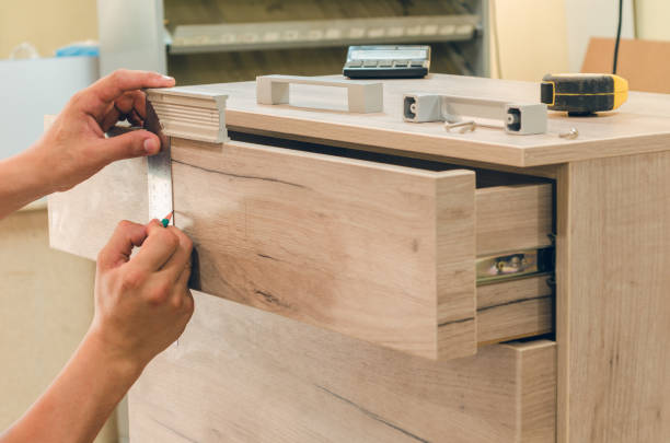 Assembling of furniture closeup Assembling furniture from chipboard, using a cordless screwdriver, close up. pressboard stock pictures, royalty-free photos & images
