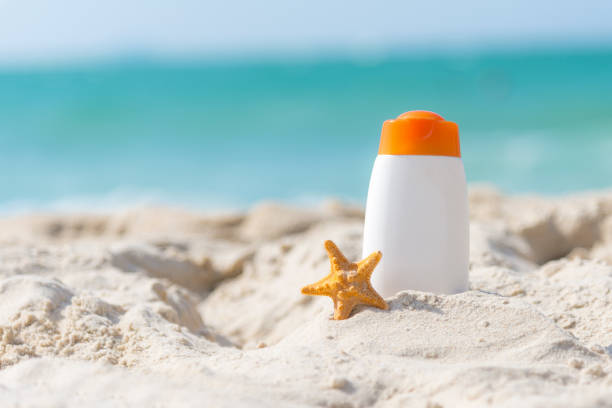 istock Protective sunscreen or sunblock and sunbath lotion in white plastic bottles with sandals on tropical beach, summer accessories in holiday, copy space 1063601692