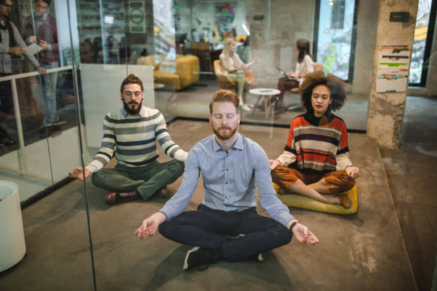 young relaxed entrepreneurs exercising yoga in the office. - yoga meditating business group of people imagens e fotografias de stock