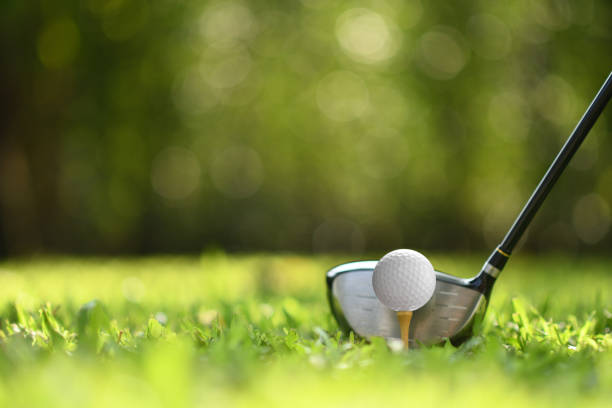 balle de golf sur l’herbe verte prêt à être frappé sur fond de parcours de golf - tee photos et images de collection