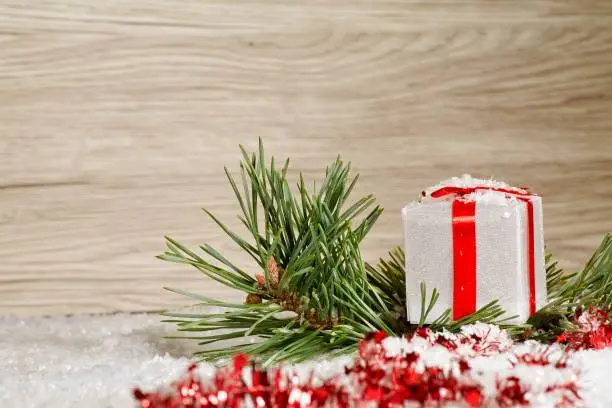 Christmas gift box and pine branches and defocused background.