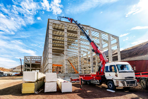 der kran (hiab) verlängern seine schaufel heben bis zum dach des neuen gebäudes für die isolierung auf der baustelle. hiab ist ein schwedischer hersteller von radlader krane, abnehmbaren containerstapler, forstwirtschaft kräne, gabelstapler lkw-montier - construction equipment large construction crane stock-fotos und bilder