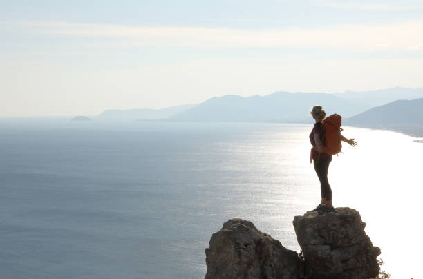 istock Female hiker arrives on summit at sunrise 1063628946