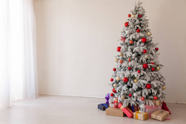 istock Christmas Decor Christmas tree with presents in a white room in winter 1063629636