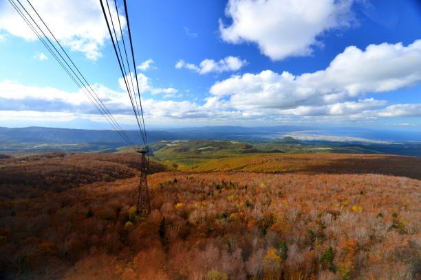 Autumn Colors and View from Hakkoda Summit Park, Aomori Prefecture Ten minutes ride in the gondola takes you to  Hakkoda Summit Park, which is located at the peak of Mt. Tamoyachi-dake, 1324 meters high. The park as well as the gondola ride commands an excellent panoramic view of the Hakkoda Mountains, Aomori City and Mutsu Bay, Tsugaru Peninsula, Shimokita Peninsula and Mt. Iwaki. 
You can enjoy beautiful autumn leaf colors as well as fresh greenery of early summer. You can also enjoy ski and snow trekking in winter. hakkoda mountain range stock pictures, royalty-free photos & images