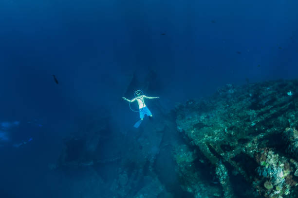 istock Free diver in the depth make ring bubbles near shipwreck 1063635982
