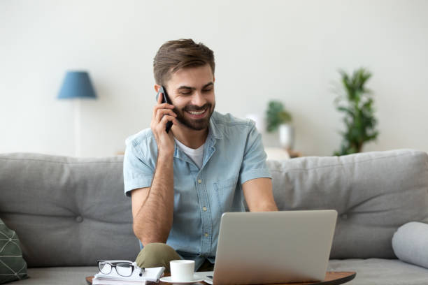 istock Cheerful male talking by mobile phone indoors 1063637440
