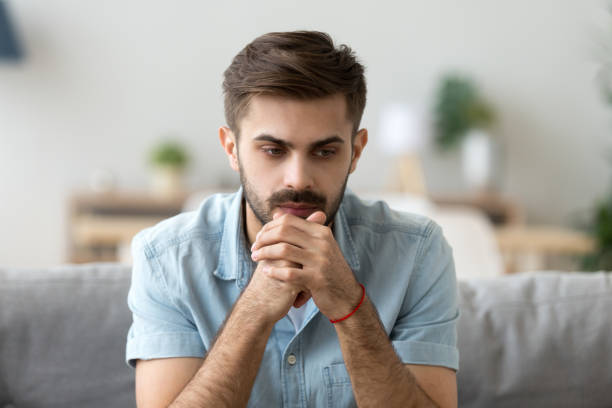istock Head shot man thinking focusing at home 1063637478
