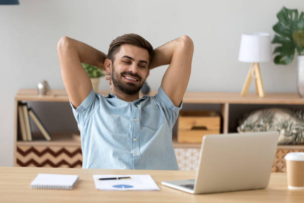 istock Relaxed man sitting holding hands behind head indoors 1063637528