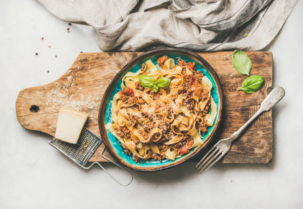 dîner de pâtes traditionnelles italiennes avec tagliatelle bolognese, composition horizontale - dishware pasta tagliatelle beef photos et images de collection