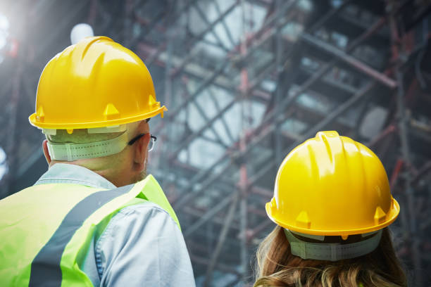 istock Rear view of male and female construction workers on site 1063638152