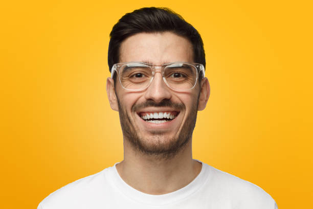 istock Optimistic young man smiling, showing white perfect teeth, isolated on yellow background. Positive emotions and happiness concept 1063638554