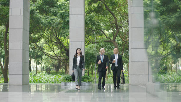 tres ejecutivos en edificio de oficinas moderno - lobby businessman office building built structure fotografías e imágenes de stock