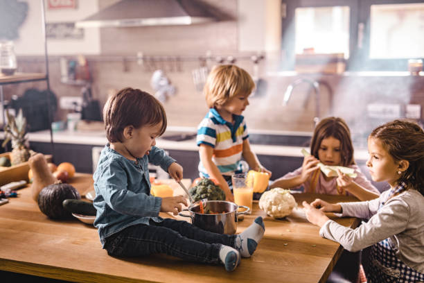 istock Group of small kids preparing lunch in the kitchen. 1063656680