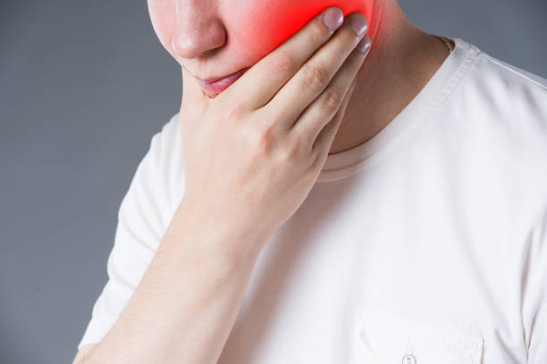 istock Man suffering from a toothache on gray background 1063657020