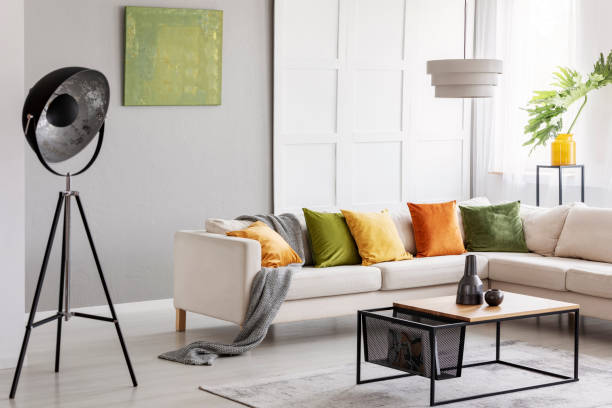 istock Two ceramic vases standing on modern coffee table in bright living room with elegant corner sofa, industrial lamp and golden lime accents 1063660056