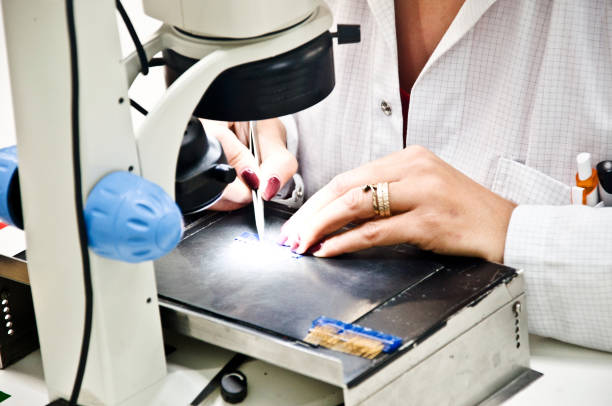 istock Female Engineer (Scientist) Examines a Specimen With A High Resolution Optical Microscope In The Laboratory 1063662166